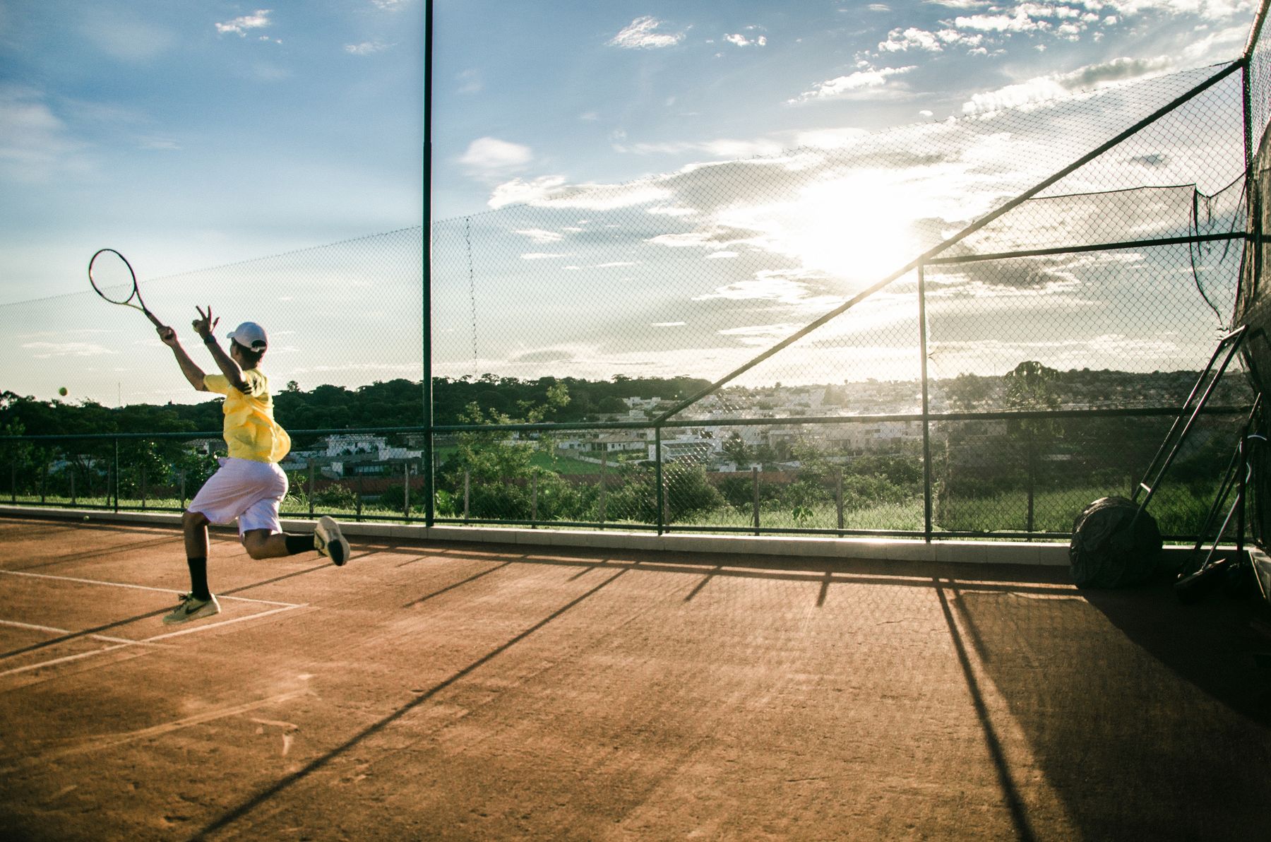 Tennisspiel auf einem Sandplatz im Abendlicht