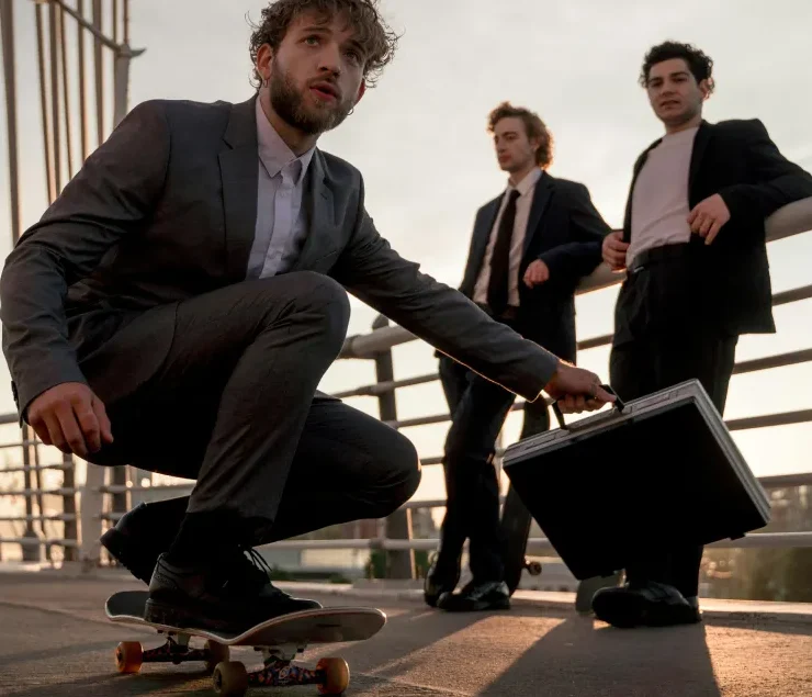 Junge Professionals in Businesskleidung auf Skateboard und mit Aktenkoffer – Sinnbild für modernes Recruiting, Employer Branding und digitale Klarheit bei aura²wei.